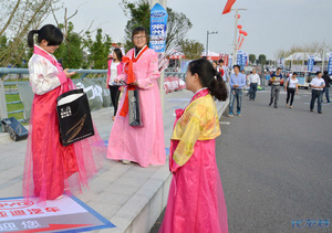 车展外围的另类风景线,3个女孩的服饰很鲜艳,